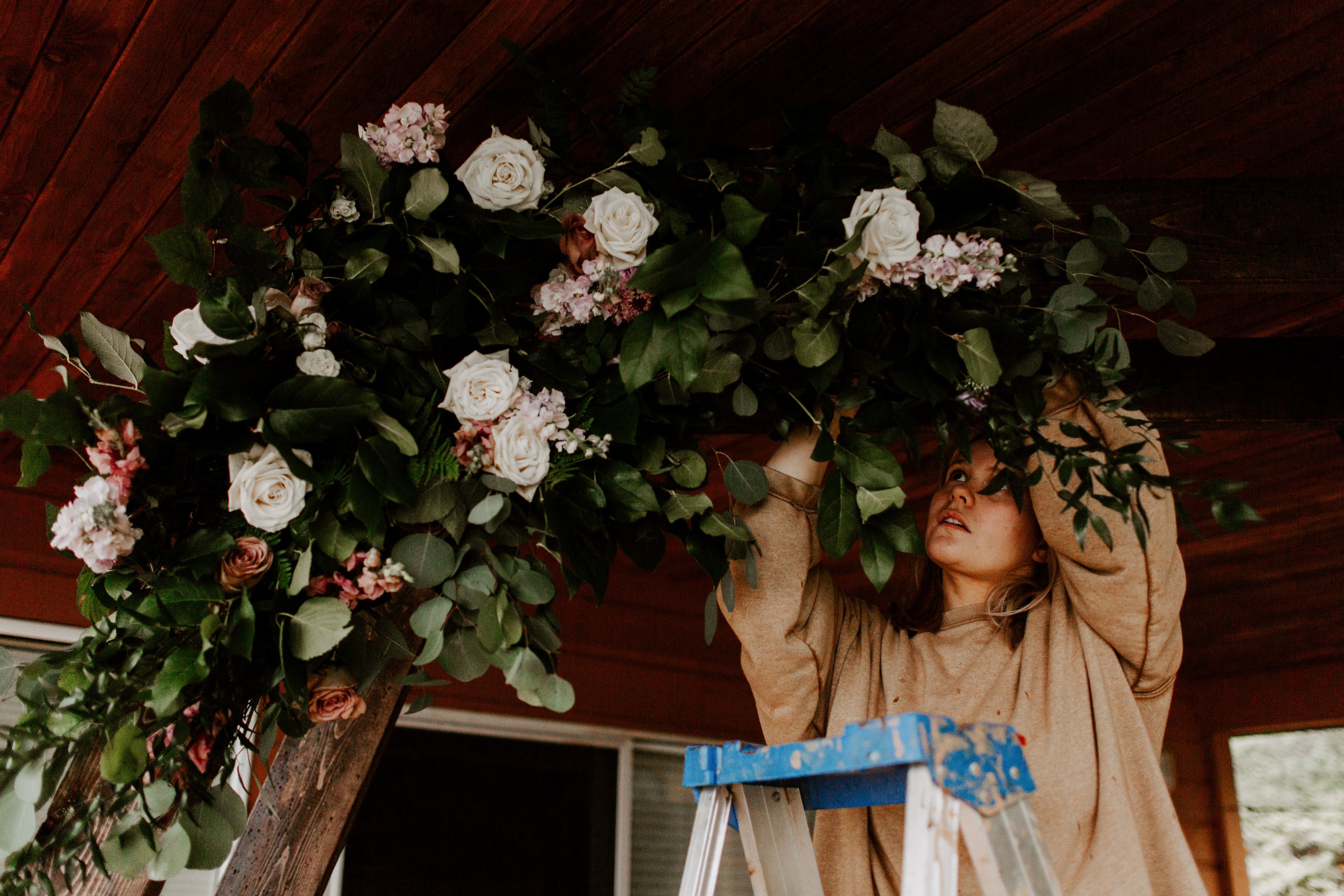 Carmen, wedding coordinator, arranging floral installation